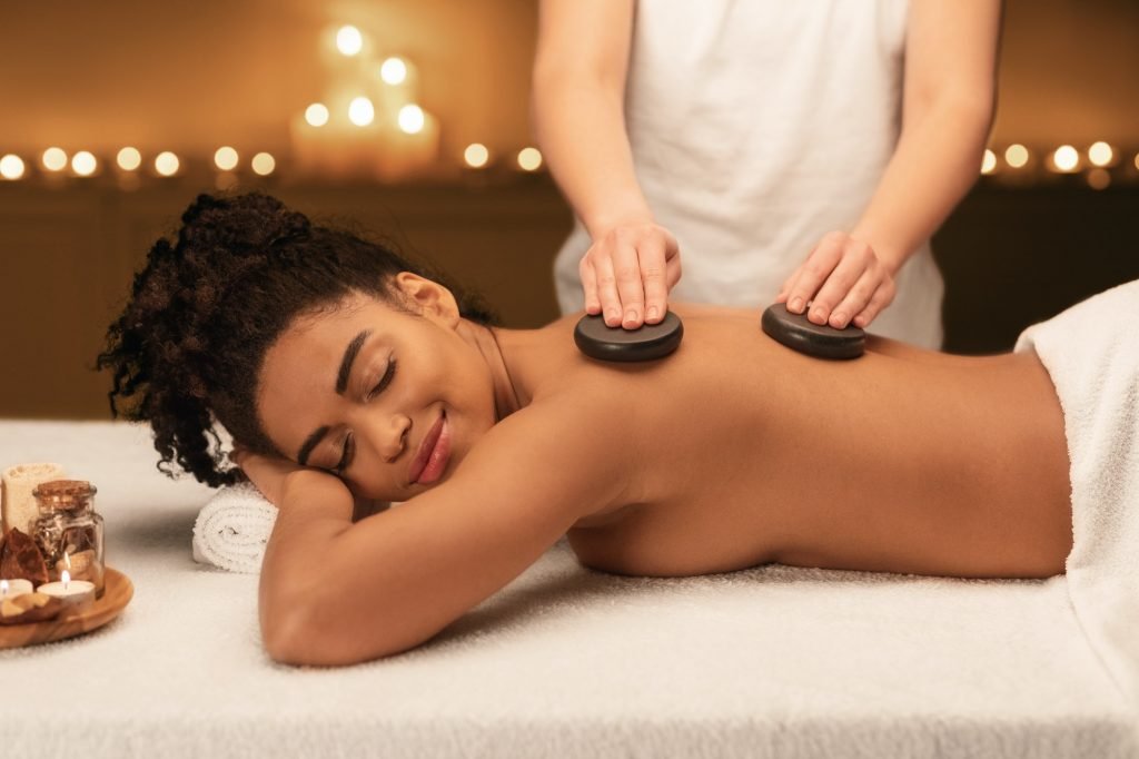 Spa therapist making professional hot stone massage